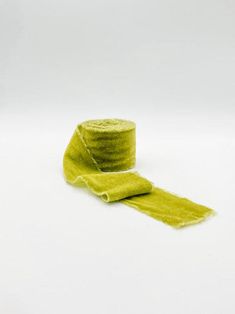 a green hat and yellow scarf on a white surface