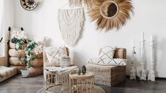 a living room filled with lots of wicker furniture and hanging wall art above the couches