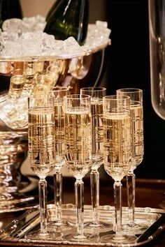 champagne glasses are sitting on a tray with ice