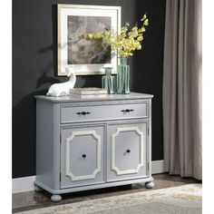 a gray and white cabinet with flowers on top