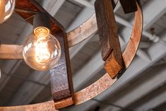 a chandelier made out of wood and metal with light bulbs hanging from it