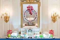 a christmas display in the middle of a room with candles and wreaths on it