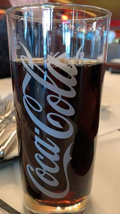 a coca cola glass sitting on top of a table