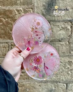 a person holding two pink plates with flowers on them