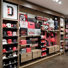 the inside of a football store with many items on shelves and hats hanging from the ceiling