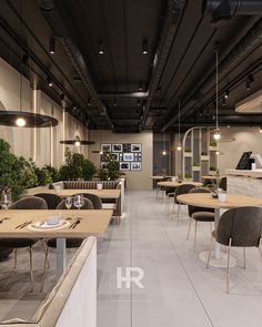 an empty restaurant with tables and chairs in the foreground, potted plants on the far wall