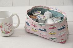 a coffee cup and mug holder with various items in it on a white counter top