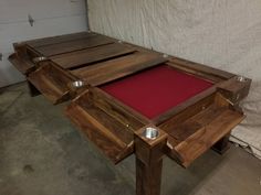 a pool table made out of wood and red felt