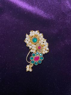 Add a touch of traditional elegance to your look with our Maharashtrian Nose Pin. This Indian Nath is a perfect accessory for lavani dance costumes, Marathi wedding bridesmaids, or anyone looking to embrace Indian culture. Nose Pin Length: 4.00 CM Metal: Alloy With Good Quality Gold Plated Color: Maroon & Green Stone: Glass Stone Faux pearls Put small-piece of double tape on nose and press the nath on it to secure it. Jewellery Care- Keep the jewellery dry, avoid contact with perfumes and water. Lavani Dance, Indian Nose Pin, Maharashtrian Nath, Marathi Nath, Bridal Nose Ring, Marathi Wedding, Nath Nose Ring, Indian Blue, Beautiful Bridal Jewelry