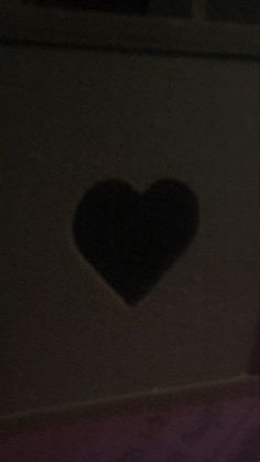 a heart shaped shadow on the side of a wall