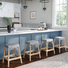 three stools sit in front of an island with blue cabinets and white countertops