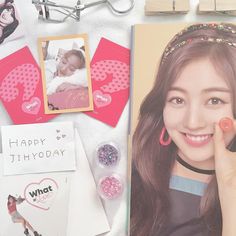 a young woman holding a cell phone next to a birthday card and other personal items