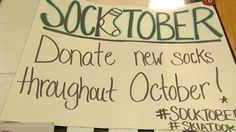 a sign posted on the side of a door that says sockstober and donations