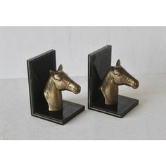 pair of brass horse head bookends on black marble bases