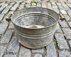 an old metal bucket sitting on the ground