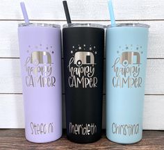 three different colored tumblers with the words happy camper on them