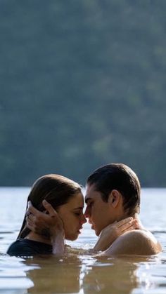 two people are in the water with their heads touching each other's foreheads