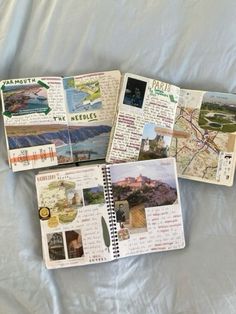 four notebooks with pictures and words on them sitting on a white sheet covered bed