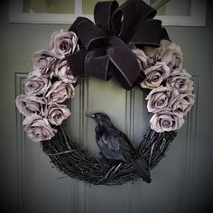 a wreath with flowers and a bird on it is hanging on the front door,