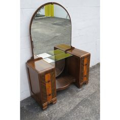 a wooden vanity with a mirror on it