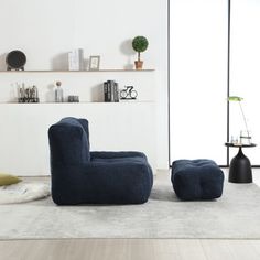 a living room filled with furniture and a white rug on top of a hard wood floor