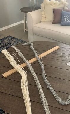 a table with some yarn on it and a wooden stick in front of the table