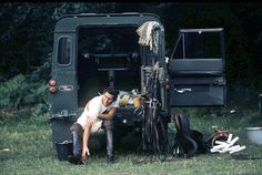 a man sitting on the ground next to a truck