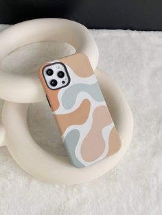 a cell phone case sitting on top of a white rug next to a circular object