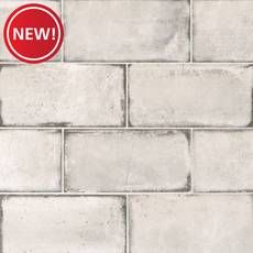 a white brick wall with a new sticker on the bottom and red sign above it