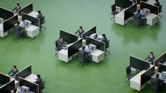 an overhead view of cubicles with people working on computers and desks in them