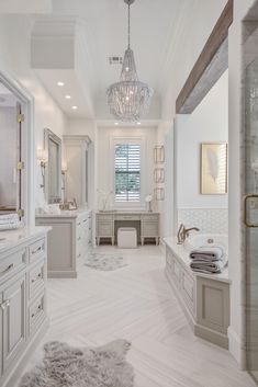 a large bathroom with two sinks, tub and chandelier