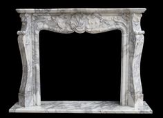 a white marble fireplace surround with carvings on it's sides and a black background