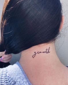 a woman with a small tattoo on her neck that says south in cursive writing