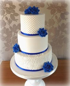 a three tiered cake with blue flowers on top