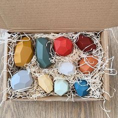 an open box filled with different colored geometric shapes on top of a wooden floor next to a white string