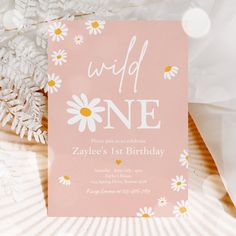 a pink birthday party card with daisies and the words wild one written on it