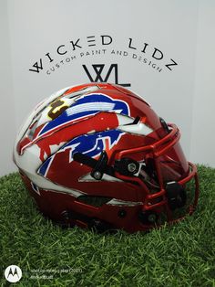 a football helmet sitting on top of a green grass covered field next to a sign