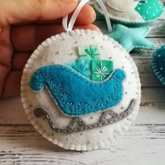 someone is holding two ornaments in their hand, one with a blue whale on it