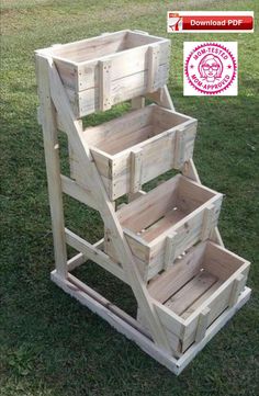 three wooden crates stacked on top of each other in the grass, with one being used as a planter