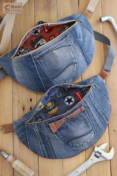 two denim purses are sitting on a wooden floor with tools in the back pocket