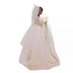 a doll dressed in a white wedding dress and veil with flowers on her head, standing against a white background