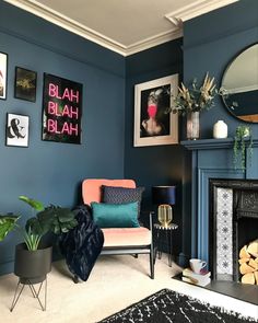 a living room with blue walls and pictures on the wall, including a fire place