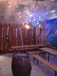 a room with snowflakes hanging from the ceiling and wooden benches on the floor