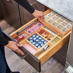 a woman is opening the drawers in her kitchen to reveal what's inside it