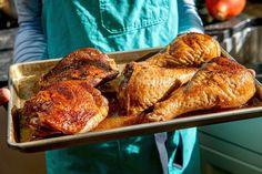 a person holding a tray with chicken on it