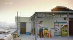 a man standing on top of a roof holding a hose