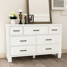 a white dresser with a mirror and vases on top