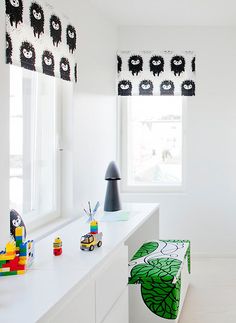 a child's room with white walls and flooring, decorated in black and green