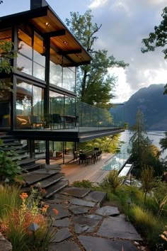 a house that is next to a body of water with stairs leading up to it