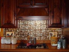 a kitchen with wooden cabinets and glass tile backsplash above the stove top area